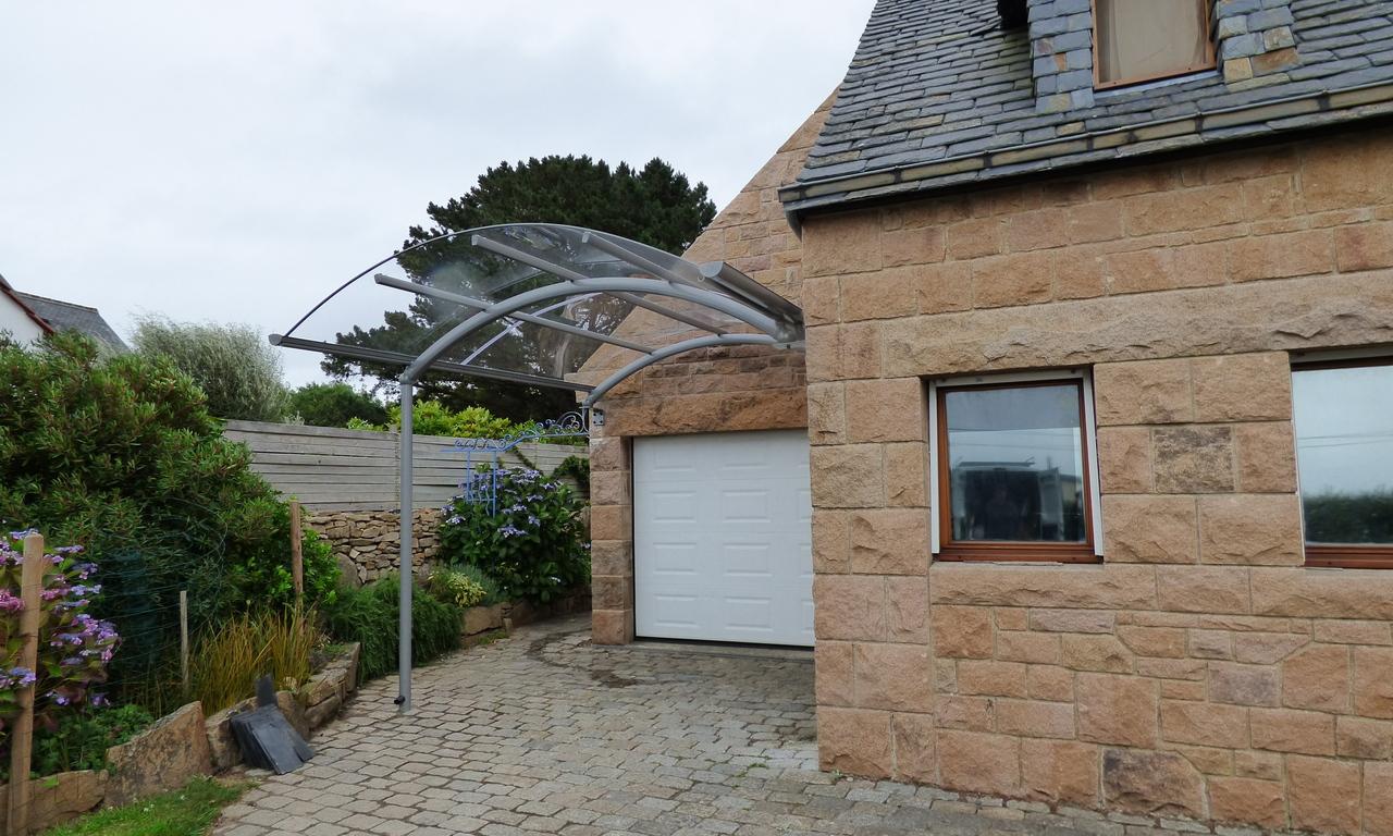 Carport adossé à la façade muni d’une évacuation des eaux de pluie intégrée.