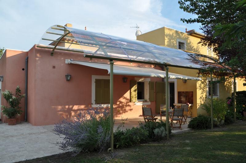 Abri de terrasse avec toit tranparent et store solaire.